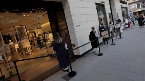 Varias docenas de personas aguardan el pasado lunes para entrar en la emblemática tienda de Zara en la calle Juan Flórez de A Coruña, la primera abierta por el fundador de Inditex, durante la primera jornada de la fase 1 de la desescalada en Galicia