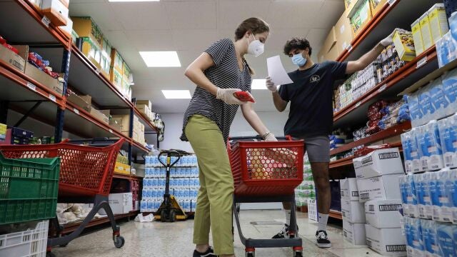 Voluntarios del economato interparroquial gestionado por Cáritas en la ciudad de Torrent (Valencia), preparan alimentos para las personas que atienden