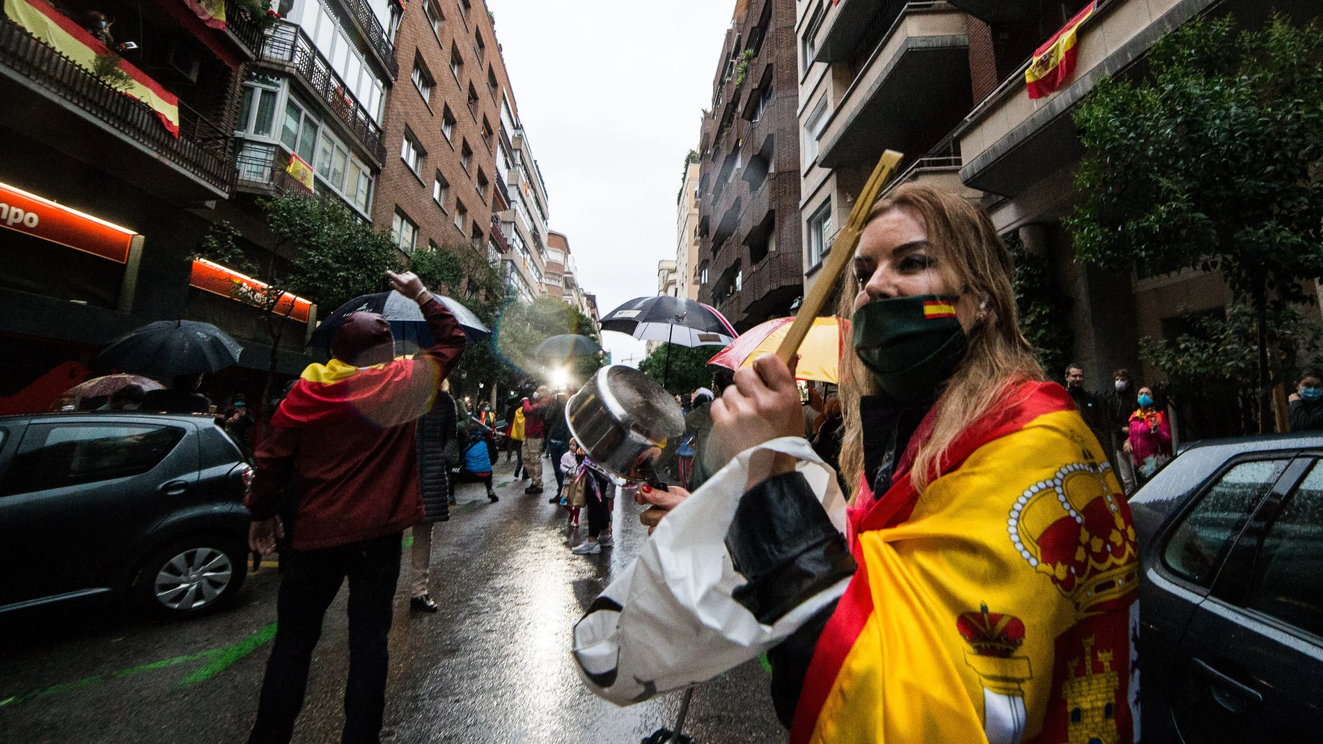 Una mujer golpea cacerola en señal de protesta durante la concentración de los vecinos del barrio madrileño de Salamanca en la calle Núñez de Balboa por la gestión del Gobierno
