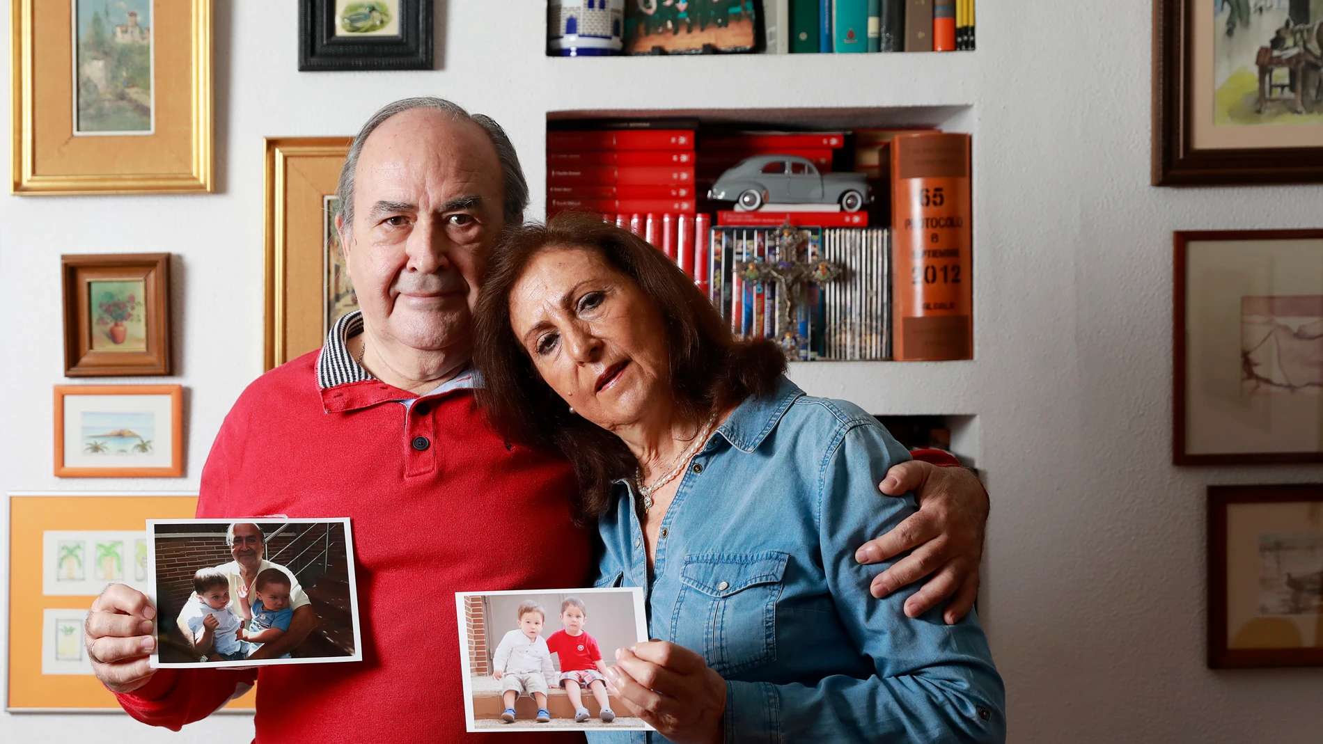 Manuel y Mª Isabel, posan en su casa de Madrid junto a unas fotografías de sus cuatro nietos, a los que desean volver a ver pronto
