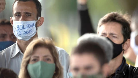 AME9478. BRASILIA (BRASIL), 13/05/2020.- Un simpatizante del presidente de Brasil, Jair Bolsonaro (fuera de cuadro), usa una mascarilla con el mensaje "Bolsonaro 2022" durante una rueda de prensa del mandatario este miércoles, frente al Palácio do Alvorada, en Brasilia (Brasil). El Gobierno de Brasil, a través de la Abogacía del Estado, entregó a la Suprema Corte los resultados de las pruebas de coronavirus a las que Bolsonaro fue sometido el pasado marzo y que, según él, han dado negativo. EFE/ Joédson Alves