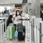 Una mujer y un niño hacen fila para tomar un vuelo