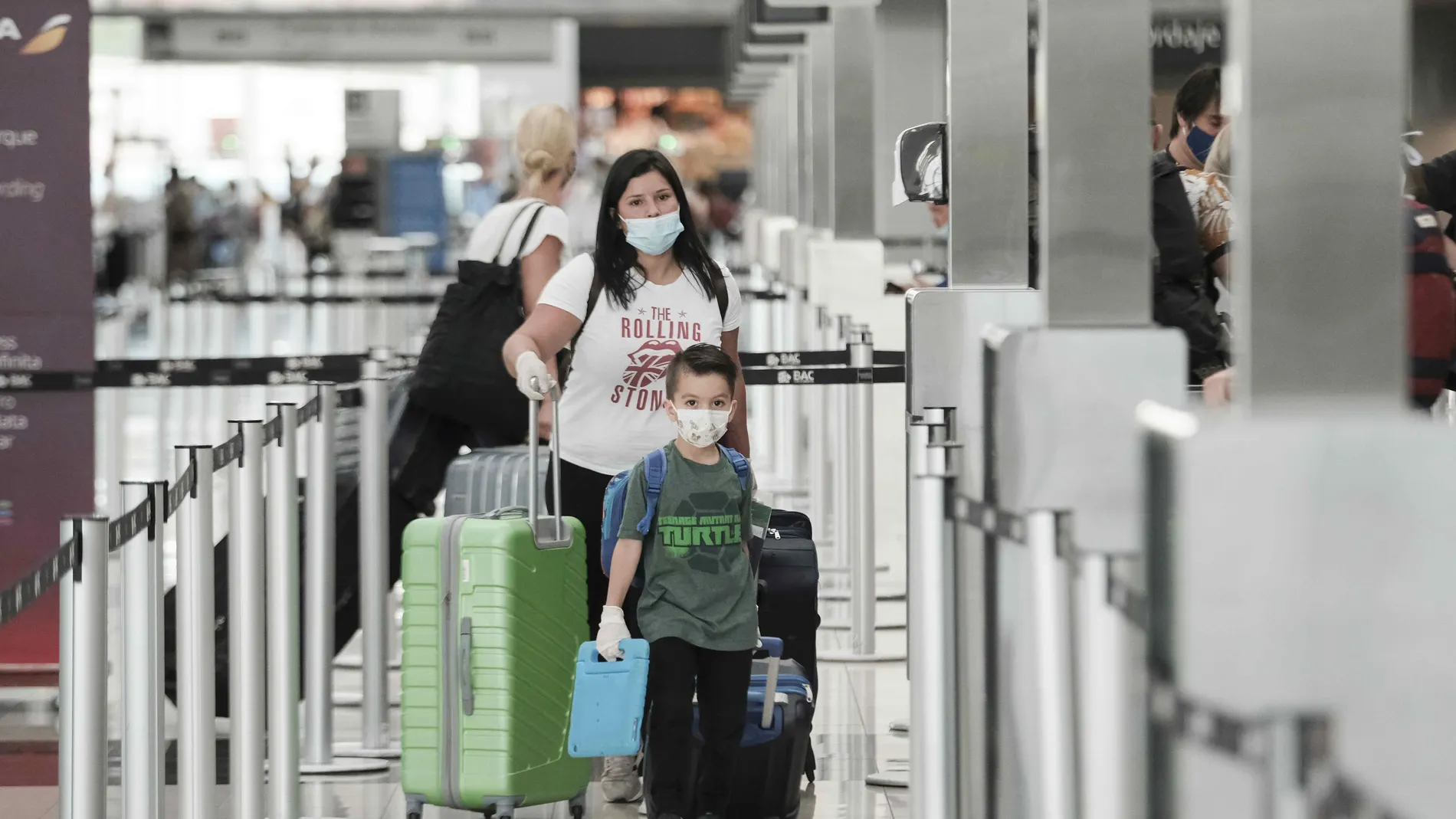 Una mujer y un niño hacen fila para tomar un vuelo