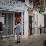 Personas esperan turno para entrar en una tienda de recuerdos de la Virgen del Rocío en el municipio de Almonte
