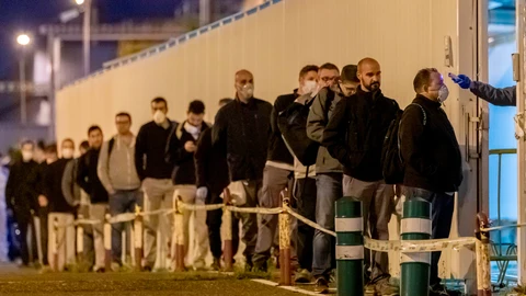 Un guardia de seguridad toma la temperatura a cada uno de los trabajadores del primer turno de la factoría de Renault de Sevilla, en la que se fabrican las cajas de cambio, tras la vuelta a la actividad con el coronavirus