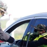 Un miembro de la Guardia de Fronteras de Lituania comprueba la documentación de un conductor en el puesto de contro de Salociai-Grenctale. Lituania, Estonia y Letonia abren sus fronteras este 15 de mayo para los ciudadanos puedan viajar entre los tres países.