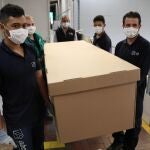 Trabajadores de la fabrica ABC Displays muestran el funcionamiento de una cama hospitalaria hecha de cartón para atender pacientes con COVID-19.