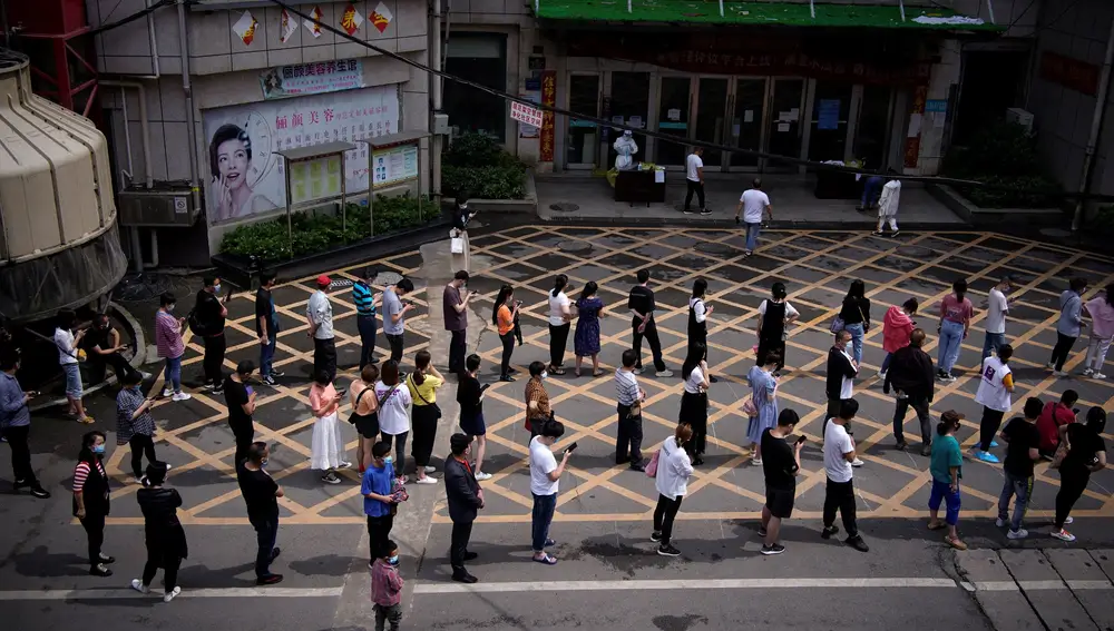 Residentes de Wuhan hacen fila para las pruebas de ácido nucleico en un complejo residencial