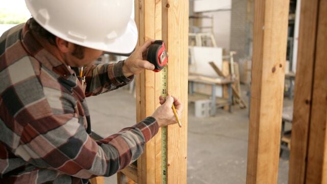 Un obrero toma medidas en una vivienda