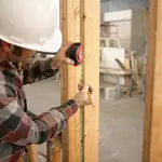 Un obrero toma medidas en una vivienda