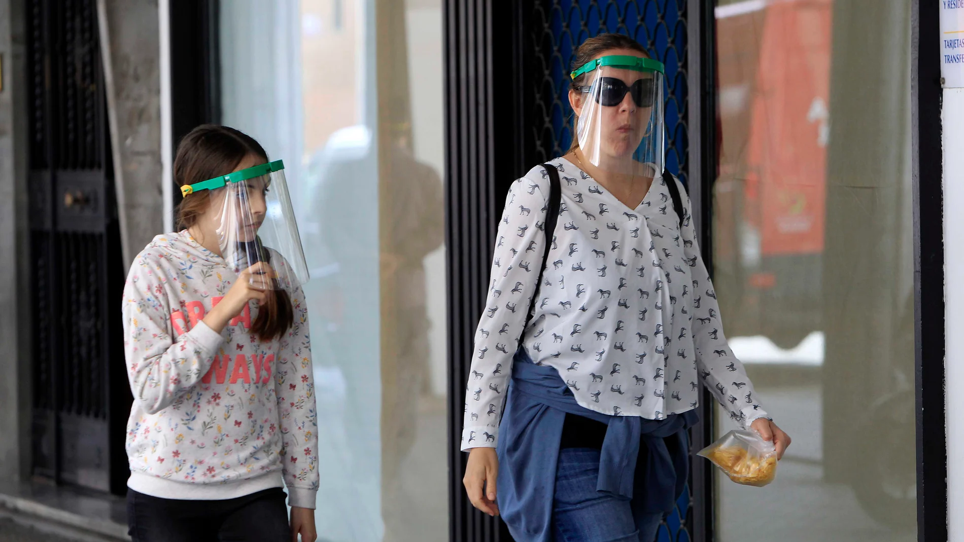 Una mujer y su hija dan un paseo en Sevilla protegidas con pantallas faciales