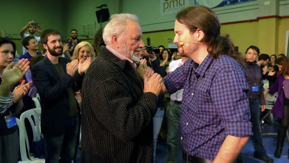 El secretario general de Podemos, Pablo Iglesias (d), se saluda con el exdirigente de IU, Julio Anguita, a la finalización del acto de precampaña que han celebrado esta tarde en el polideportivo cordobés del barrio de Fátima. EFE/Rafa Alcaide.