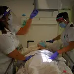 Dos sanitarios preparan a un paciente para una prueba de rayos X en un hospital público británico
