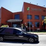 Un conductor protegido con una mascarilla espera en el interior de un vehículo de los servicios funerarios en la entrada del Tanatorio Sur de Madrid