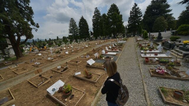 Una mujer visita la tumba de un familiar en el cementerio de Bérgamo