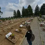 Una mujer visita la tumba de un familiar en el cementerio de Bérgamo