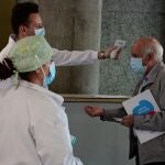 Un sanitario toma la temperatura a un hombre que accede al Hospital de Alcorcón en Madrid, este lunes pasado.