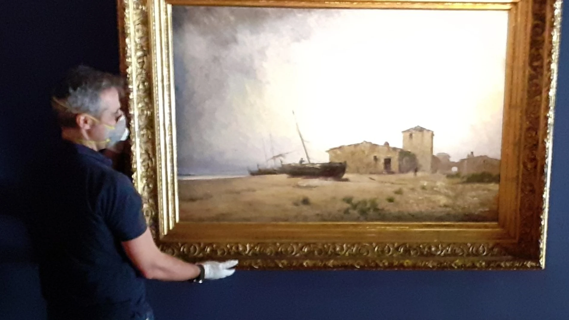El galerista Gabriel Pinós sujeta una obra de Modest Urgell en la sala Gothsland