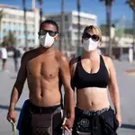 Una pareja usa mascarilla mientras practican ejercicio en Barcelona.
