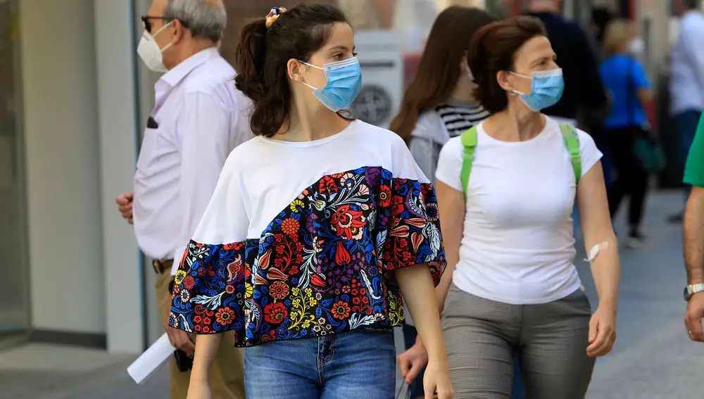 Personas paseando con mascarilla por una calle de Sevilla durante el estado de alarma