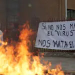 Una pancarta tras una barricada de neumáticos incendiados reza &quot;Si nos nos mata el virus, nos mata el hambre&quot; en Santiago de Chile