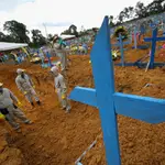 Trabajadores cavan fosas comunes en un cementerio de Manao
