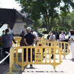 Varias personas esperan su turno en un puesto del mercadillo de Pinto.