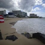 A Puerto Rican flag flies on an empty beach at Ocean Park, in San Juan, Puerto Rico, Thursday, May 21, 2020. Puerto Rico is cautiously reopening beaches, restaurants, churches, malls, and hair salons under strict conditions as the U.S. territory emerges from a two-month lockdown despite dozens of new coronavirus cases reported daily. (AP Photo/Carlos Giusti) PUERTO RICO OUT-NO PUBLICAR EN PUERTO RICO