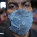 Una hombre se cubre el rostro de manera precaria mientras espera ayuda humanitaria en la iglesia del barrio de El Cementerio de Caracas.