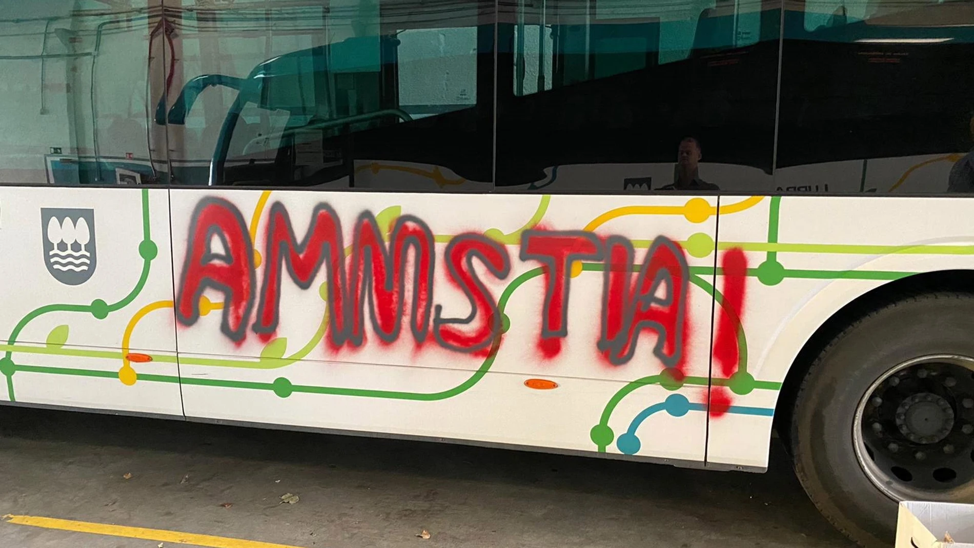 Encapuchados hacen pintadas en un autobús en apoyo a Patxi Ruiz en Azpeitia.