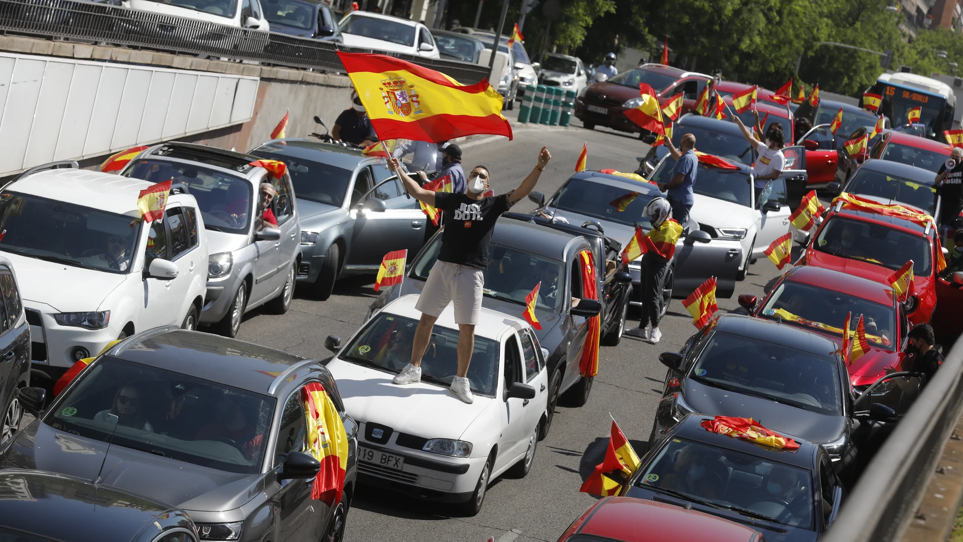 Coches y motos, con pancartas y banderas de España, circulan por las calles de la capital en la manifestación de Vox para pedir la dimisión del Gobierno de Pedro Sánchez por su gestión durante la pandemia del Covid-19. En Madrid.