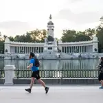 Varias personas hacen deporte a primera hora del dia junto al Estanque del Parque del Retiro de Madrid