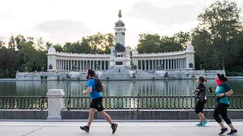 Varias personas hacen deporte a primera hora del dia junto al Estanque del Parque del Retiro de Madrid