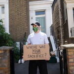 Manifestantes con mascarilla protestan frente a la casa de Domminc Cummings con carteles que se preguntan: ¿Dónde está tu sacrificio?