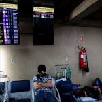 Dos pasajeros esperan en un aeropuerto