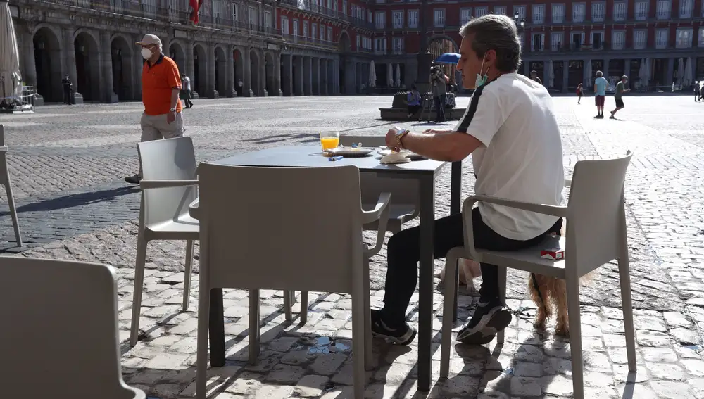 Un hombre desayuna en la terraza de un bar de la Plaza Mayor en Madrid este lunes