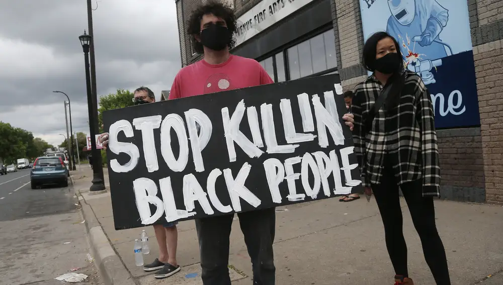Varios manifestantes junto al lugar donde murió el hombre negro a manos de la policía