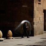 Un hombre pasea por las calles de Salamanca mientras mira el móvil