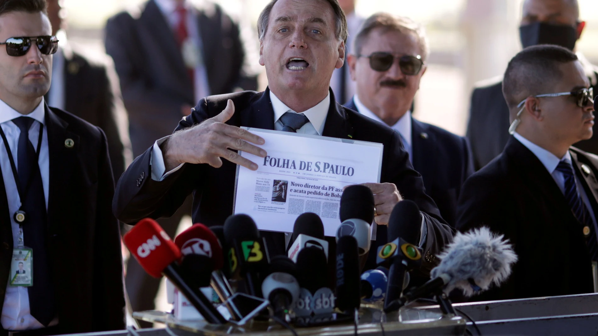 FILE PHOTO: Brazil's President Jair Bolsonaro holds a paper with a print of the first page of newspaper Folha de Sao Paulo, as he leaves Alvorada Palace, amid the coronavirus disease (COVID-19) outbreak in Brasilia, Brazil May 5, 2020. REUTERS/Ueslei Marcelino/File Photo