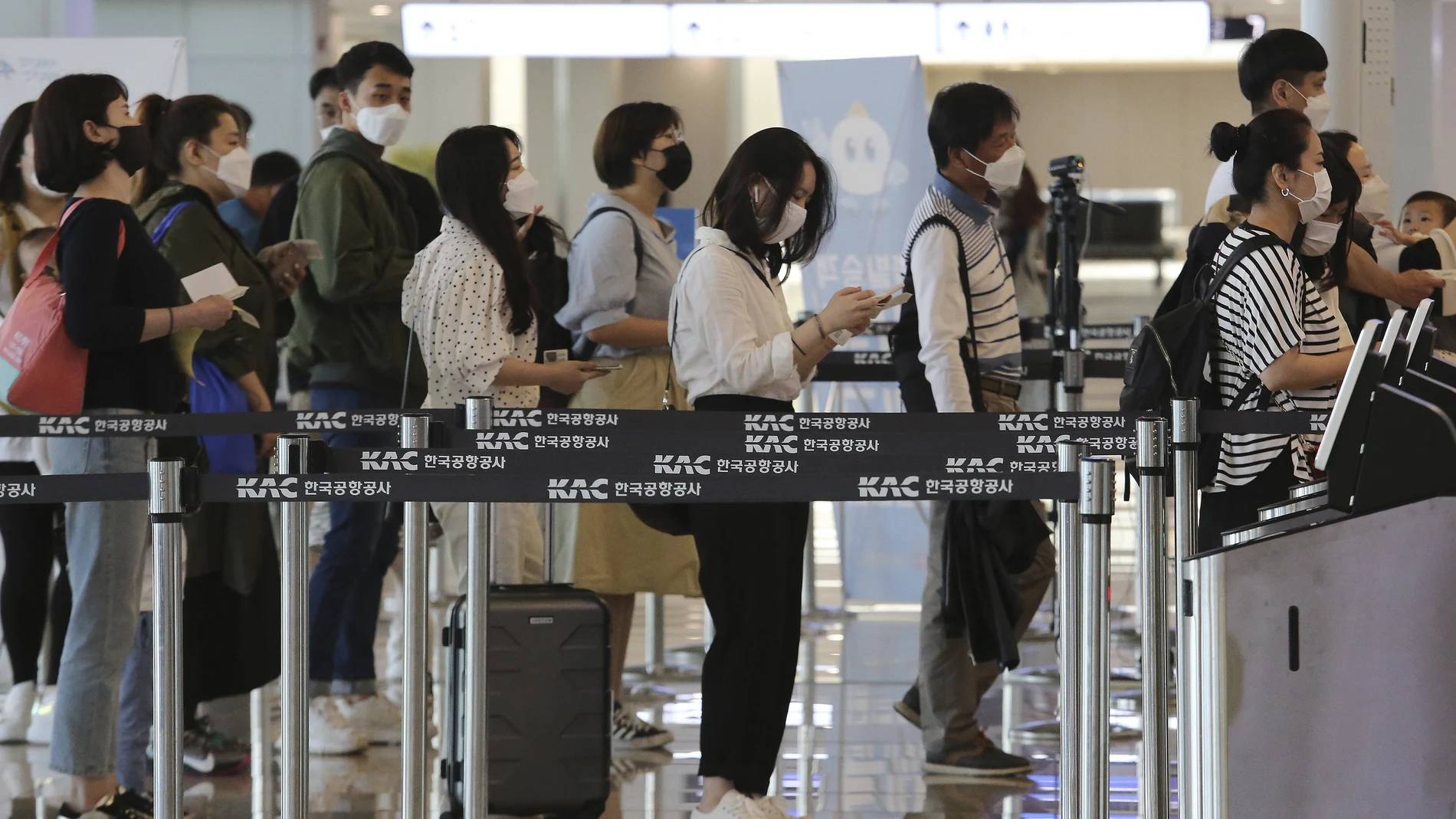 Pasajeros con mascarillas antes de coger un vuelo doméstico en Seúl