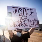 Los Angeles (United States), 28/05/2020.- People hold placards during a protest following the death of George Floyd, in Los Angeles, California, USA, 27 May 2020. A bystander's video posted online on 25 May appeared to show George Floyd, 46, pleading with arresting officers that he couldn't breathe as an officer knelt on his neck, in Minnesota. The unarmed black man later died in police custody. (Protestas, Estados Unidos) EFE/EPA/ETIENNE LAURENT