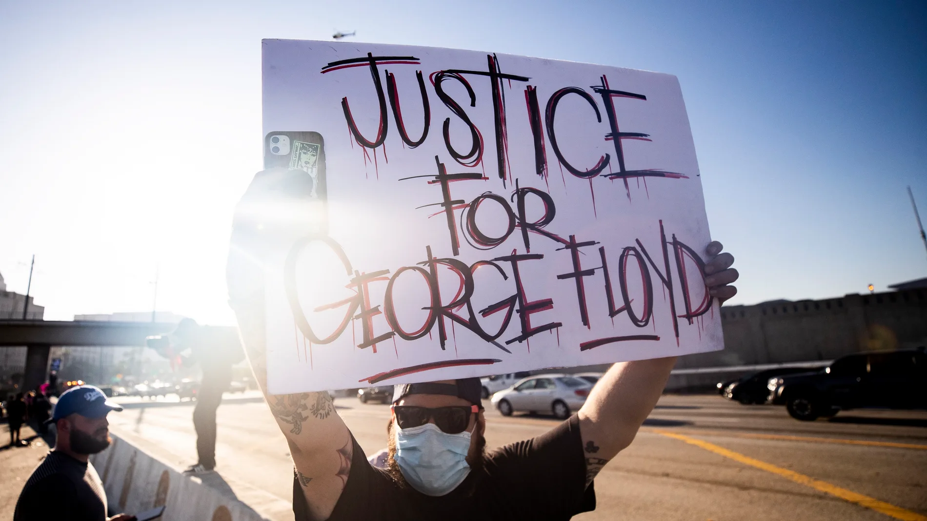 Los Angeles (United States), 28/05/2020.- People hold placards during a protest following the death of George Floyd, in Los Angeles, California, USA, 27 May 2020. A bystander's video posted online on 25 May appeared to show George Floyd, 46, pleading with arresting officers that he couldn't breathe as an officer knelt on his neck, in Minnesota. The unarmed black man later died in police custody. (Protestas, Estados Unidos) EFE/EPA/ETIENNE LAURENT