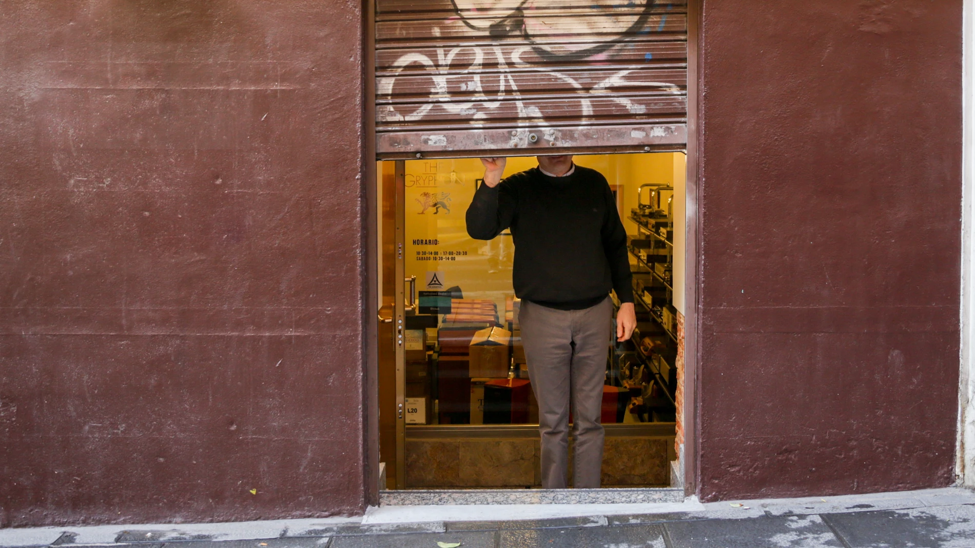 Un autónomo echa el cierre de su negocio tras su jornada laboral días, en Madrid