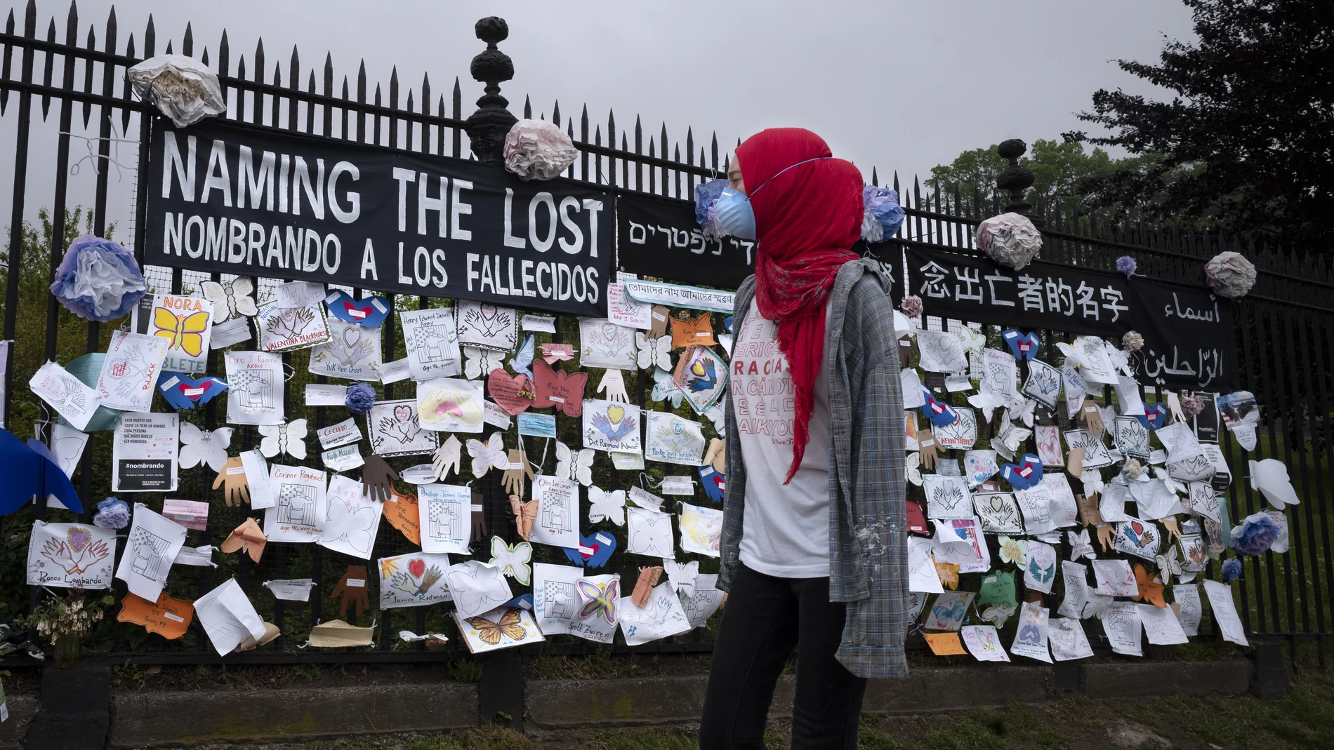 Una mujer pasa frente a un muro en Brooklyn en memoria de las víctimas del coronavirus