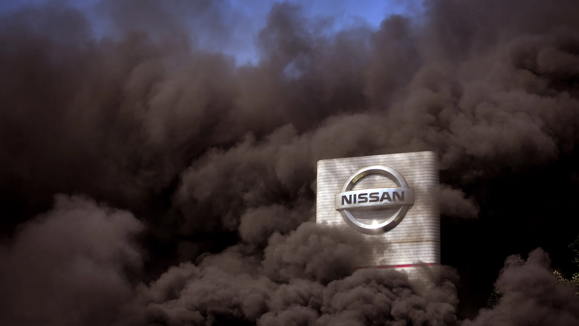 El humo e las protestas envuelve un cartel de Nissan