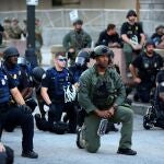 Agentes de las Fuerzas de Seguridad se arrodillan durante una protesta contra la muerte de George Floyd, en el centro de Atlanta, Georgia