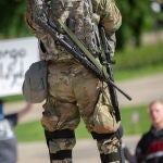 Dos hombres protestan delante de un miembro de la Guardia Nacional en Minneapolis