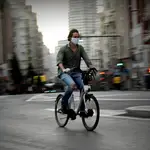 Gente por la calle con bici , patinete y moto . Coronavirus .