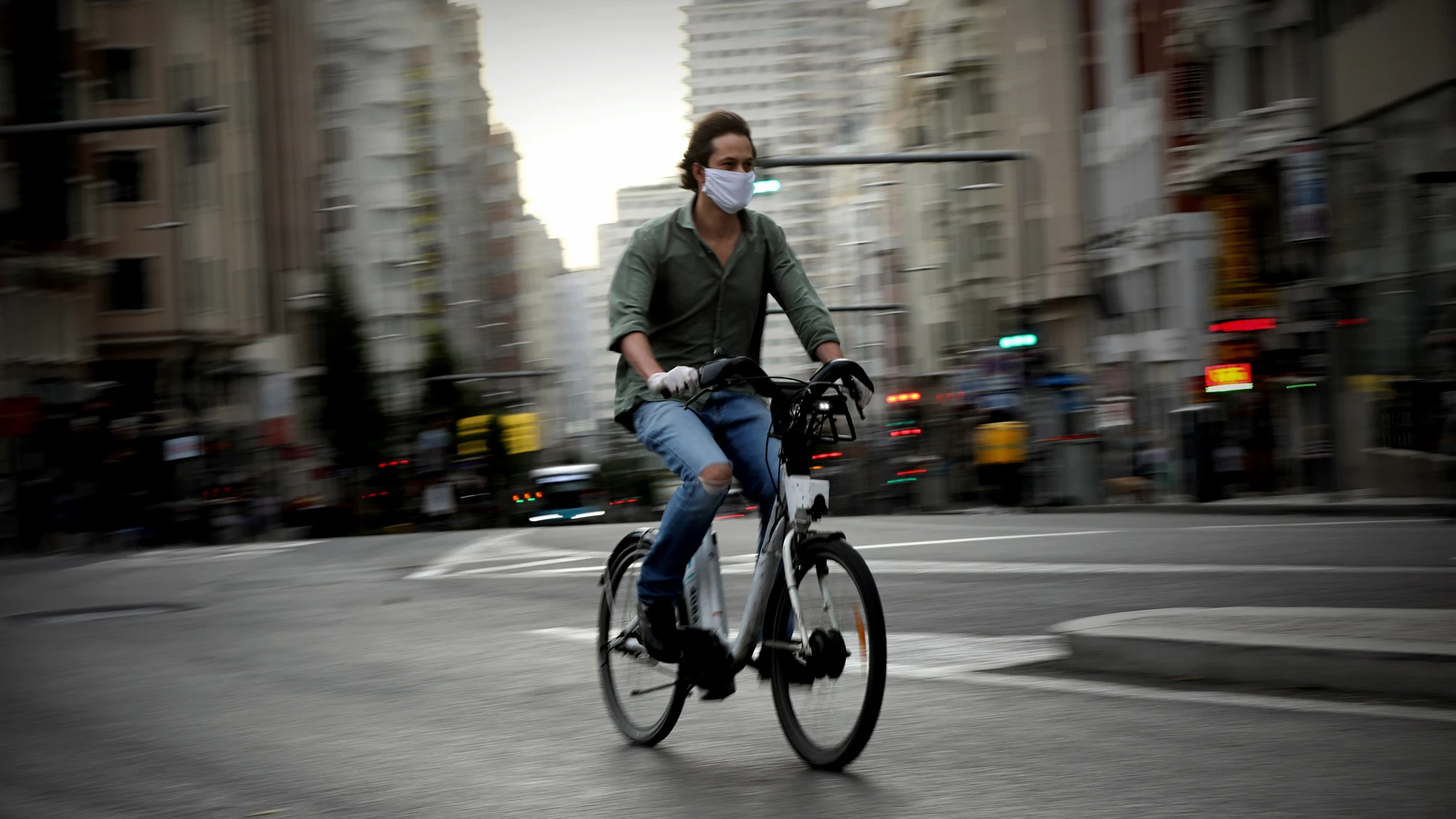 Gente por la calle con bici , patinete y moto . Coronavirus .