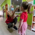 Olimpia Selva regenta el centro de educación infantil "Mi pequeña escuela", en la pedanía murciana de La Alberca, toma la temperatura a una niña antes de entrar